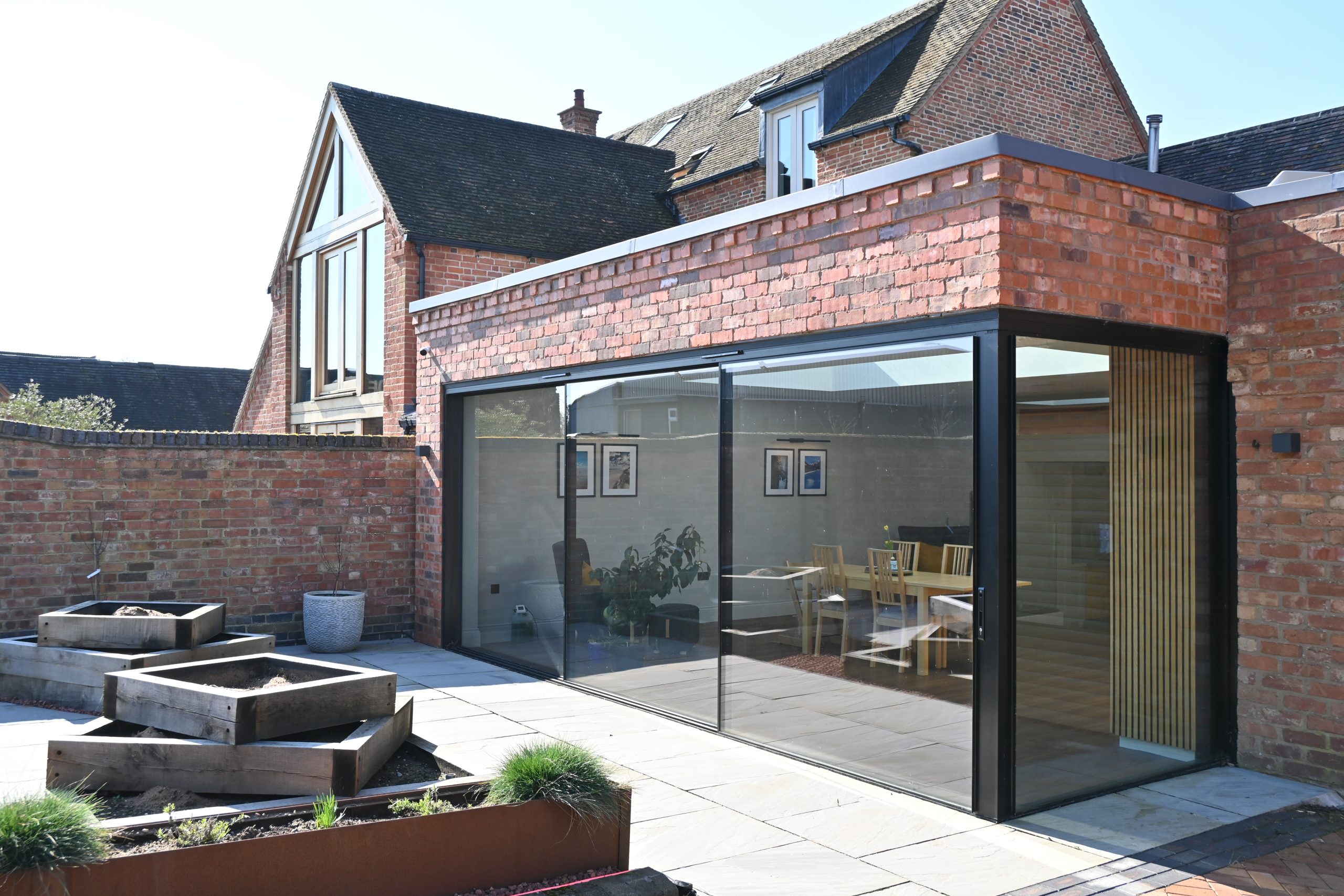 Contemporary glazed house extension with brick and timber exterior
